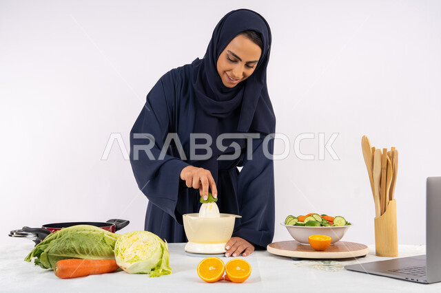 اعداد المشروبات الصحية، اتباع نظام غذائي صحي، تعلم مهارة الطهي باستخدام الحاسوب، بورتريه لسيدة عربية خليجية اماراتية محجبة ترتدي عباءة تقوم بعصر الليمون، ربة منزل سعودية تقوم بتحضير طبق مفيد، مشاركة الوصفة عبر مواقع التواصل الاجتماعي، خلفية بيضاء