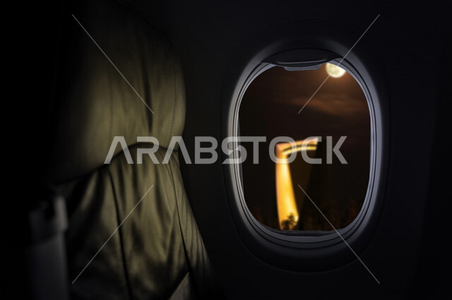 صورة لنافذة الطائرة تطل على برج المملكة في مدينة الرياض في المملكة العربية السعودية ، صورة جوية من داخل الطائرة لمركز المملكة ، ابراج وناطحات سحاب في السعودية