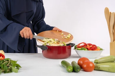 حب تعلم مهارة الطهي وإعداد الطعام، ربة منزل سعودية تقوم بتحضير وصفة بالخضراوات الطازجة، احترافية اختيار الخضار، بورتريه مقرب لسيدة عربية خليجية اماراتية ترتدي عباءة تحضر وجبة صحية مفيدة، خلفية بيضاء