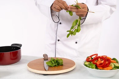 شغف التدرب على مهارة الطهي وإعداد الطعام، شيف سعودي يقوم بتحضير سلطة الخضراوات الطازجة، استخدام المكونات والمقادير المناسبة للوجبة، احترافية اختيار الخضار، بورتريه مقرب لرجل عربي خليجي اماراتي يرتدي زي العمل يحضر طبق صحي مفيد، خلفية بيضاء