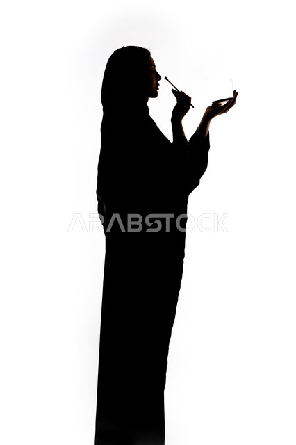 Marketing of cosmetic products, the concept of femininity and softness, a silhouette of an Emirati Gulf Arab woman, makeup tools tutorial, interest in beauty and external appearance, using one of the cosmetic tools (eyeshadow brush), white background