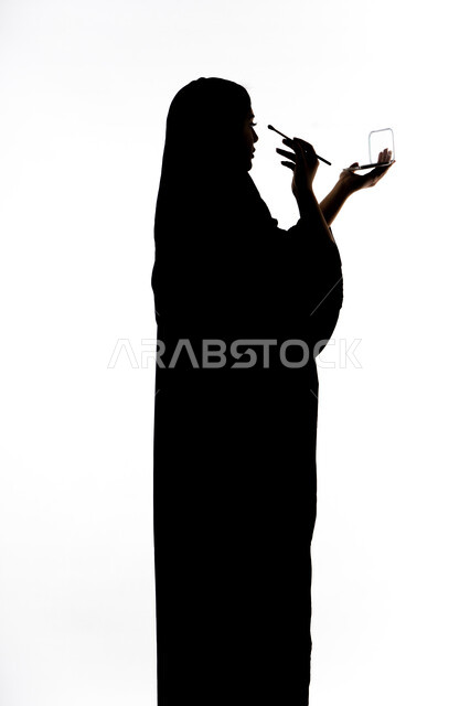 صورة ظلية لمرأة عربية خليجية اماراتيه، أدوات مكياج تتوريال ، الإهتمام بالجمال والمظهر الخارجي ، إستخدام إحدى أدوات التجميل ( فرشاة ظل العيون ) ،  التسويق لمنتجات التجميل ، خلفية بيضاء