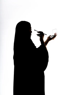 الإهتمام بالجمال والمظهر الخارجي ، إستخدام إحدى أدوات التجميل ( فرشاة ظل العيون ) ،  التسويق لمنتجات التجميل ، صورة ظلية لمرأة عربية خليجية اماراتيه، أدوات مكياج تتوريال ، خلفية بيضاء