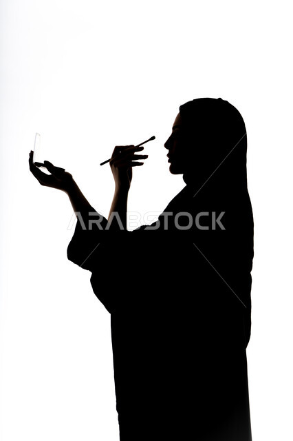 التسويق لمنتجات التجميل ، إستخدام إحدى أدوات التجميل ( فرشاة ظل العيون ) ، صورة ظلية لمرأة عربية خليجية اماراتيه، الإهتمام بالجمال والمظهر الخارجي ، أدوات مكياج تتوريال ، خلفية بيضاء