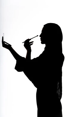 إستخدام إحدى أدوات التجميل ( فرشاة ظل العيون ) ، التسويق لمنتجات التجميل ،  صورة ظلية لمرأة عربية خليجية اماراتيه، الإهتمام بالجمال والمظهر الخارجي ، أدوات مكياج تتوريال ، خلفية بيضاء