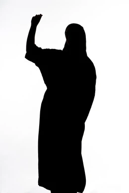 Spending free time playing and entertaining, expressions of victory and triumph, entertaining modern technologies, silhouette of an Emirati Gulf Arab woman raising her hand with enthusiastic gestures, white background