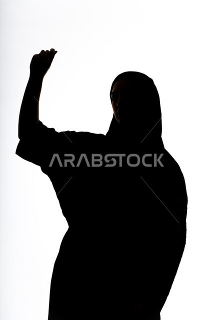 تعابير الفوز و الانتصار, قضاء أوقات الفراغ باللعب والترفيه ، تقنيات حديثة مسلية, صورة ظلية لإمرأة عربية اماراتيه خليجية ترفع يدها بايماءات الحماس ، خلفية بيضاء