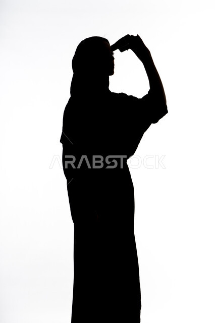 إيماءات السرور والاستمتاع، رؤية الاشياء البعيدة و تقريبها, حب الاستكشاف و المغامرة, الاشاره الى شئ بعيد،  صورة ظلية لمراه عربية خليجية اماراتية تحمل بيدها منظار ثنائي العينين و تنظر الى شيء ما، خلفية بيضاء