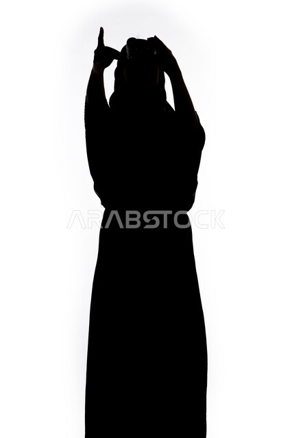 الاشاره الى شئ بعيد، رؤية الاشياء البعيدة و تقريبها, حب الاستكشاف و المغامرة, صورة ظلية لمراه عربية خليجية اماراتية تحمل بيدها منظار ثنائي العينين و تنظر الى شيء ما بإيماءات السرور والاستمتاع، خلفية بيضاء