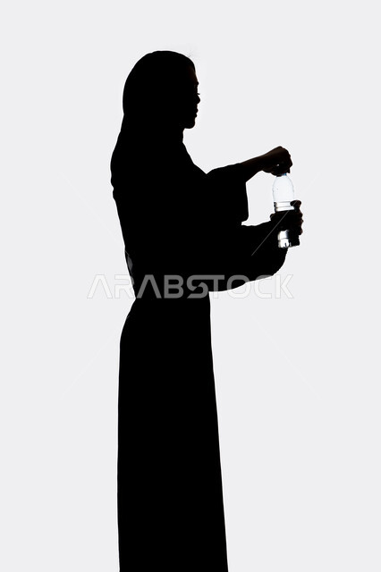 المحافظة على سلامة الجهاز المناعي،أهمية شرب الماء النقي للمحافظة على بشرة نضرة، صورة ظلية لامراه عربي خليجيه اماراتيه تقوم بشرب المياه من عبوة بلاستيكية،  التخلص من سموم الجسم، خلفية بيضاء