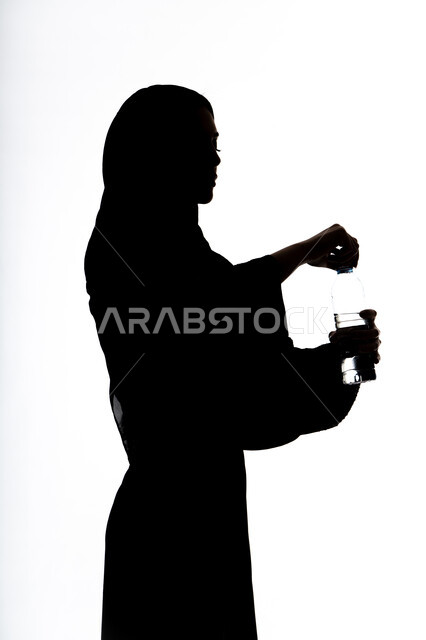 أهمية شرب الماء النقي للمحافظة على بشرة نضرة، صورة ظلية لامراه عربي خليجيه اماراتيه تقوم بشرب المياه من عبوة بلاستيكية، المحافظة على سلامة الجهاز المناعي، التخلص من سموم الجسم، خلفية بيضاء