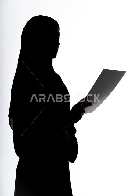 الأبحاث والتقارير ، قراءة الملاحظات والمعلومات ،مراجعه خطط العمل، متابعة الخطط والمشاريع ، التعليم والثقافة ،صورة ظلية لمرأة عربية خليجية اماراتيه، بيدها أوراق خاصة بالعمل ، خلفية بيضاء