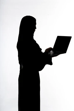 Integrating modern technology into daily life, conducting a live broadcast, social media, using a laptop, completing work tasks remotely, using modern technical devices, silhouette of an Arab Gulf Emirati woman, white background