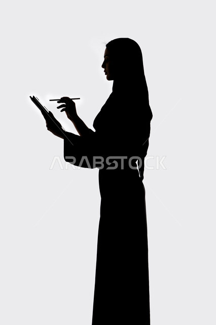 Using modern technology, conducting a live broadcast, completing work tasks remotely, social media, integrating modern technology into daily life, taking souvenir selfies using a tablet, a silhouette of an Arab Gulf Emirati woman, white background
