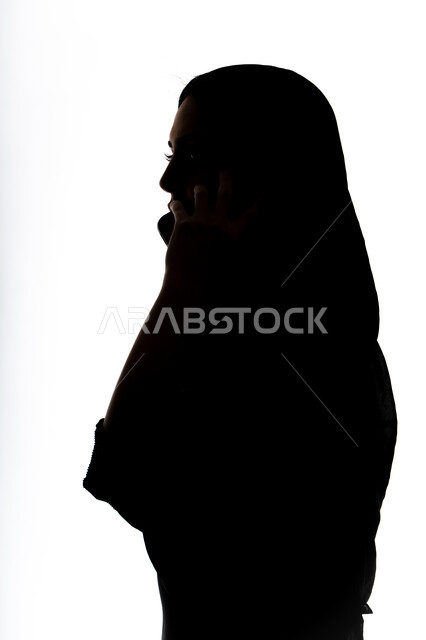 اجراء بث مباشر ،إستخدام اجهزة تقنية حديثة ،التقاط صور سيلفي تذكاريه بإستخدام الهاتف المحمول ، اجراء مكالمه هاتفيه ،صورة ظلية لمرأة عربية خليجية اماراتيه ،وسائل التواصل الإجتماعي ، خلفية بيضاء