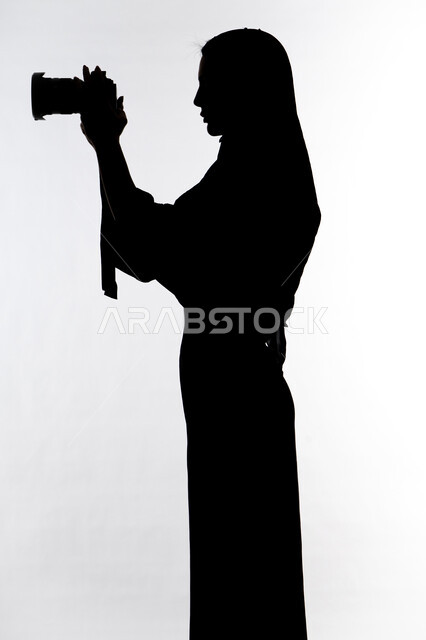 High-resolution camera, professional photography, photography hobby, taking souvenir photos, silhouette of an Arab Gulf Emirati woman, holding a high-resolution camera in her hand, Emirati photographer, white background