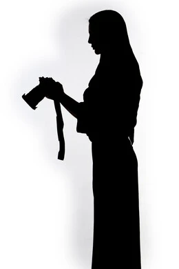 هواية التصوير ، إلتقاط الصور التذكارية ، كاميرا عالية الدقة ،صورة ظلية لامراه عربيه خليجيه اماراتيه ، تحمل بيده كاميرا تصوير عالية الدقة ، مصوره اماراتي ، إحتراف التصوير ، خلفية بيضاء