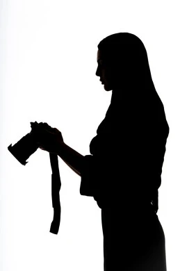 إلتقاط الصور التذكارية ،هواية التصوير ، كاميرا عالية الدقة ،صورة ظلية لامراه عربيه خليجيه اماراتيه ، تحمل بيده كاميرا تصوير عالية الدقة ، مصوره اماراتي ، إحتراف التصوير ، خلفية بيضاء