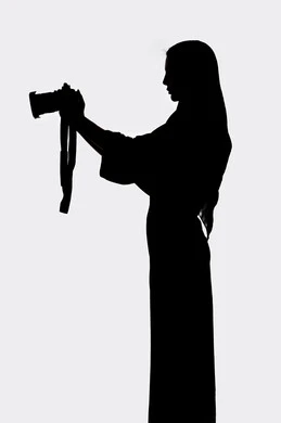 صورة ظلية لامراه عربيه خليجيه اماراتيه ، تحمل بيده كاميرا تصوير عالية الدقة ، مصوره اماراتي ، إحتراف التصوير ،هواية التصوير ، إلتقاط الصور التذكارية ، كاميرا عالية الدقة ، خلفية بيضاء