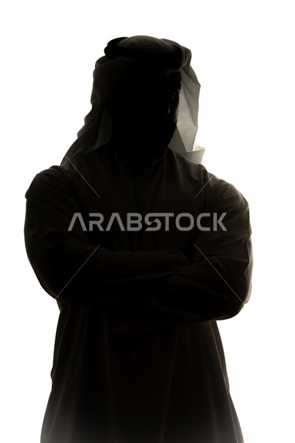 الوقوف بايدي متقاطعه، الاهتمام بالأناقة والمظهر الخارجي، مفهوم الرجوله والثقه بالنفس ،صورة ظلية لرجل عربي خليجي اماراتي، خلفية بيضاء