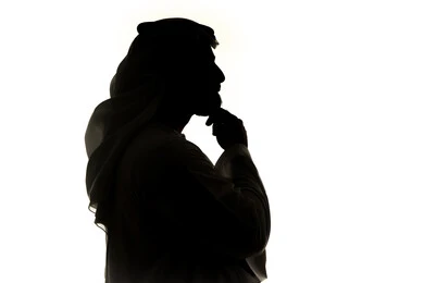 التأمل والتخطيط للمستقبل، ايجاد حل لمشكلة ما،  صورة ظلية لرجل عربي خليجي اماراتي يضع يده على ذقنه ينظر الى مكان ما بايماءات التفكير والتركيز، تعابير شرود الذهن والتمعن، خلفية بيضاء