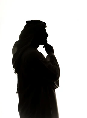 ايجاد حل لمشكلة ما، التأمل والتخطيط للمستقبل، صورة ظلية لرجل عربي خليجي اماراتي يضع يده على ذقنه ينظر الى مكان ما بايماءات التفكير والتركيز، تعابير شرود الذهن والتمعن، خلفية بيضاء
