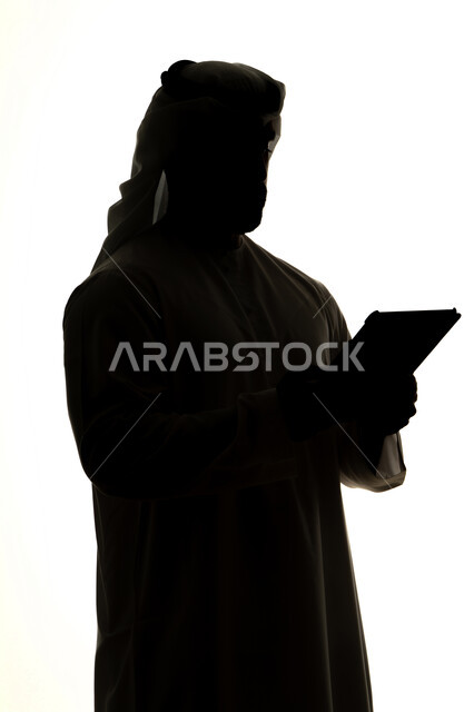 Online shopping using a tablet, completing tasks remotely, integrating modern technologies into daily life, silhouette of an Arab Gulf Emirati man, professions and jobs, white background