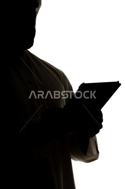 Completing tasks remotely, online shopping using a tablet, integrating modern technologies into daily life, silhouette of an Arab Gulf Emirati man, professions and jobs, white background