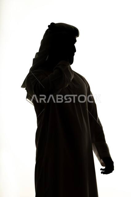 الدردشه عبر الانترنت،دمج التقنيات الحديثه فى الحياه اليوميه ،إنجاز المهام عن بعد، التواصل الإجتماعي ،إجراء مكالمة فيديو بإستخدام الهاتف المحمول ، الإتصال والدردشة ، صورة ظلية لرجل عربي خليجي اماراتي ، خلفية بيضاء
