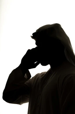 التواصل الإجتماعي ،إجراء مكالمة فيديو بإستخدام الهاتف المحمول ، الإتصال والدردشة ،الدردشه عبر الانترنت، دمج التقنيات الحديثه فى الحياه اليوميه ، إنجاز المهام عن بعد، صورة ظلية لرجل عربي خليجي اماراتي ، خلفية بيضاء