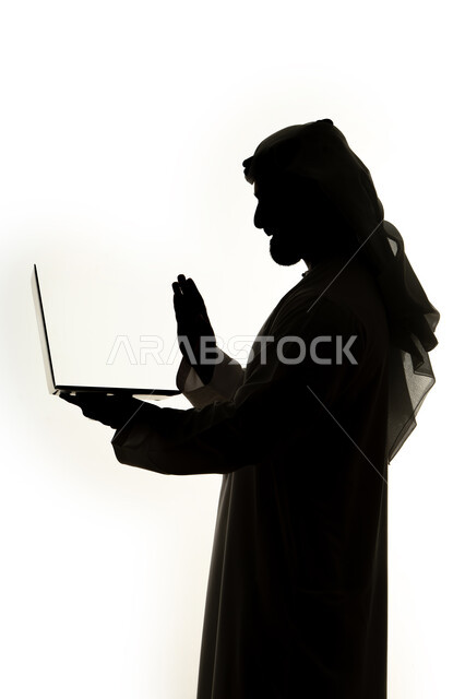 تصفح الإنترنت ، إستخدام اجهزة تكنولوجيا ،دمج التقنيات الحديثه فى الحياه اليوميه ، صورة ظلية لرجل عربي خليجي اماراتي ، إستخدام جهاز الحاسوب المحمول ، العمل عن بعد ، التسويق الإلكتروني ، مهن ووظائف ، خلفية بيضاء