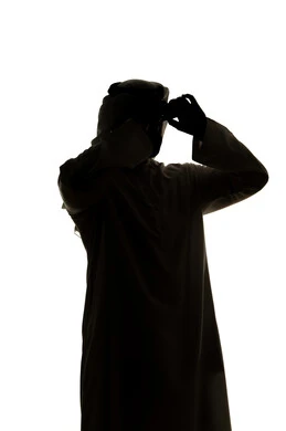 صورة ظلية لرجل عربي خليجي اماراتي يحمل بيده منظار ثنائي العينين و ينظر الى شيء ما ،إيماءات السرور والاستمتاع، رؤية الاشياء البعيدة و تقريبها,  حب الاستكشاف و المغامرة,  خلفية بيضاء