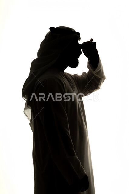 إيماءات السرور والاستمتاع، رؤية الاشياء البعيدة و تقريبها,  حب الاستكشاف و المغامرة,صورة ظلية لرجل عربي خليجي اماراتي يحمل بيده منظار ثنائي العينين و ينظر الى شيء ما ، خلفية بيضاء