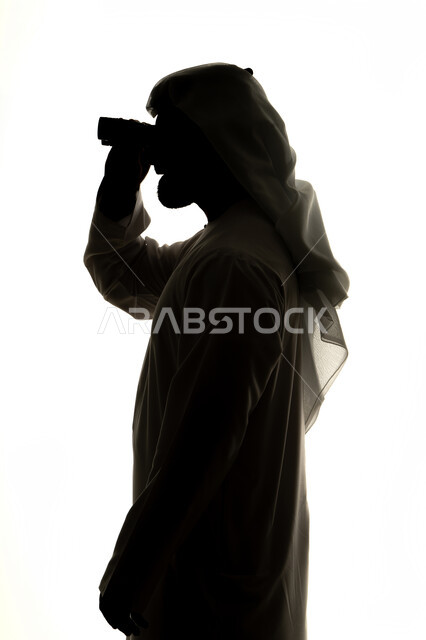 Seeing distant things and bringing them closer, love of exploration and adventure, silhouette of an Emirati Gulf Arab man holding binoculars and looking at something with gestures of pleasure and enjoyment, white background