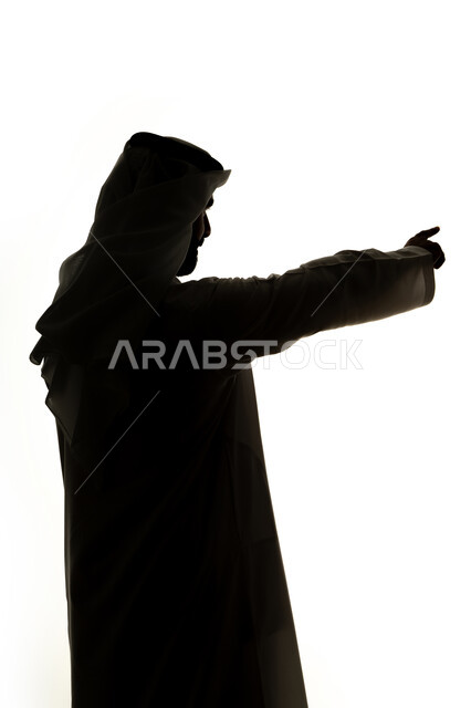إشارات وحركات يدين تدل على هذا المكان (هنا)، تحديد موقع معين، النظر الى شيء ما ، صورة ظلية لرجل عربي خليجي اماراتي يشير بأصابعه الى هدف محدد، خلفية بيضاء