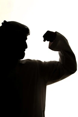 لياقة بدنية وصحة، إستعراض القوة البدنية ،صورة ظلية لرجل عربي خليجي اماراتي ، يرفع يده بكفه مقبوضه ، القوة العضلية ، عرض العضلات ، جسم صحي ، خلفية بيضاء