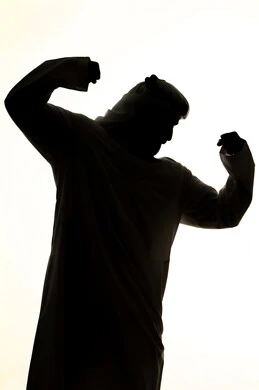 إستعراض القوة البدنية ، لياقة بدنية وصحة، صورة ظلية لرجل عربي خليجي اماراتي ، يرفع يده بكفه مقبوضه ، القوة العضلية ، عرض العضلات ، جسم صحي ، خلفية بيضاء
