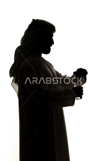 Schedule management, organizing and arranging time, silhouette of an Arab Gulf Emirati man wearing a wristwatch looking at it, checking the time, hot drinks, setting work appointments, white background