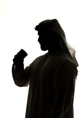 Mood booster with caffeine, sipping hot drinks and warm winter herbs, silhouette of an Arab Gulf Emirati man holding a cup, hot drinks, white background