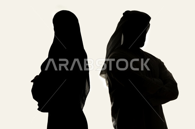 قضاء اوقات ممتعه مع العائله ، الاناقه والاهتمام بالظهر الخارجي ،صورة ظلية لزوجان عربيان خليجيان اماراتي، يقفان بإستقامة ، بإيدي متقاطعة ، ينظران إلى الكاميرا ، خلفية بيضاء