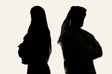 قضاء اوقات ممتعه مع العائله ، الاناقه والاهتمام بالظهر الخارجي ،صورة ظلية لزوجان عربيان خليجيان اماراتي، يقفان بإستقامة ، بإيدي متقاطعة ، ينظران إلى الكاميرا ، خلفية بيضاء