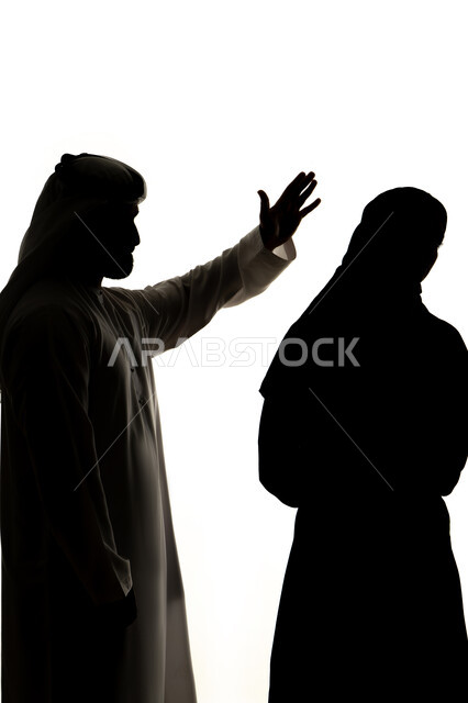 شجار بين الزوجين ، ازمة في العلاقات الاسرية، جدالات وسوء تفاهم اسري، مشاكل وصراعات عائلية، مفهوم العنف ضد المرأة، صورة ظلية لزوجان عربيان خليجيان اماراتيان ، يتشجاران مع بعضهم ، صراع اسري ،  خلفية بيضاء