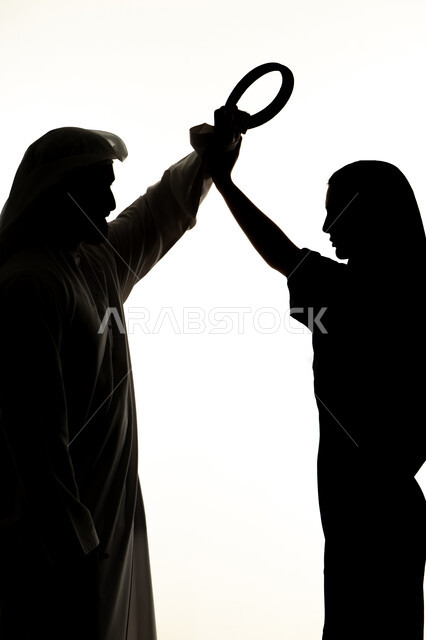 Family arguments and misunderstandings, exposure to violence and beatings by men, quarrel between spouses, crisis in family relations, family problems and conflicts, silhouette of an Arab Gulf Emirati couple, quarreling with each other, white background