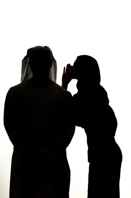 ايماءات الانصات والتركيز بالكلام، النميمة والتحدث عن شخص ما، التحدث بصوت منخفض، صورة ظلية لامراه عربيه خليجيه اماراتيه تهمس بإذن زوجها، مفهوم الكتمان وحفظ الأسرار بين الشقيقات، خلفية بيضاء