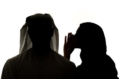 النميمة والتحدث عن شخص ما، ايماءات الانصات والتركيز بالكلام، التحدث بصوت منخفض، صورة ظلية لامراه عربيه خليجيه اماراتيه تهمس بإذن زوجها، مفهوم الكتمان وحفظ الأسرار بين الشقيقات، خلفية بيضاء