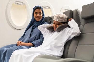 الإحساس بالكسل والخمول, رحلة سياحية عائلية، امرأة عربية عمانية ترتدي الحجاب و العباءة برفقة ولدها داخل الطائرة ، الشعور بالتعب والارهاق والحاجة الى النوم والراحة، قضاء العطلة الصيفية برفقة العائلة، خطوط الطيران العماني