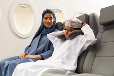 تعابير النعاس والإرهاق, رحلة سياحية عائلية، امرأة عربية عمانية ترتدي الحجاب و العباءة برفقة ولدها في الطائرة، قضاء العطلة الصيفية ، خطوط الطيران العماني