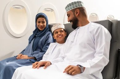 رحلة سياحية عائلية، قضاء وقت ممتع داخل الطائرة , عائله عربيه خليجيه عمانية ترتدي الزي التقليدي تجلس على المقعد داخل الطائرة فى رحله جويه , ايماءات السعاده و السرور, خطوط الطيران العماني