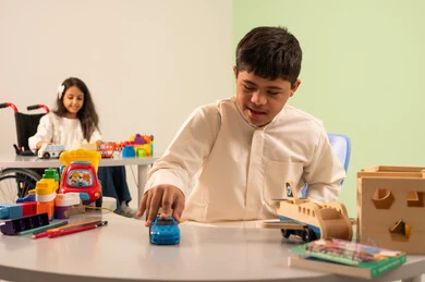 تشجيع ورعاية وتطوير مهارات الأطفال،  اهتمام المجتمع السعودي بأصحاب الهمم,  الابداع وتنمية المهارات الذهنيه والفكريه في الروضات السعودية ، بنت عربيه سعوديه ترتدي الزي الكاجوال تجلس على كرسي متحرك، تقوم بتركيب المكعبات بتعابير السعاده ،نشاطات ترفيهية لذوي الاحتياجات الخاصة ،ولد عماني مصاب بمتلازمه داون يقوم باللعب بالالعاب البلاستيكيه الملونه