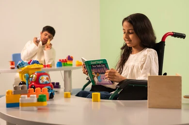 بنت عربيه سعوديه ترتدي الزي الكاجوال تجلس على كرسي متحرك، تقوم بقراءه الكتب التعليميه الملونه بتعابير السعاده ،مفهوم هوايه المطالعه ،قضاء اوقات ممتعه ، تنمية المهارات الذهنيه والفكريه في الروضات السعودية ، تعزيز النشاط الذهني ،  ولد عماني مصاب بمتلازمه داون يقوم بتركيب المكعبات